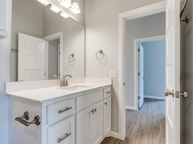 817 Carrie Ct, Purcell, OK 73080 - bathroom featuring baseboards, wood finished floors, and vanity