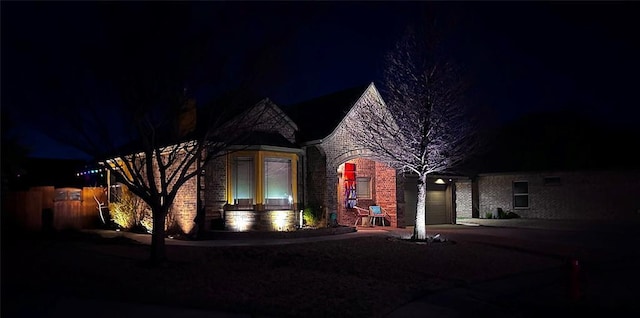 view of front of property featuring brick siding, driveway, and an attached garage