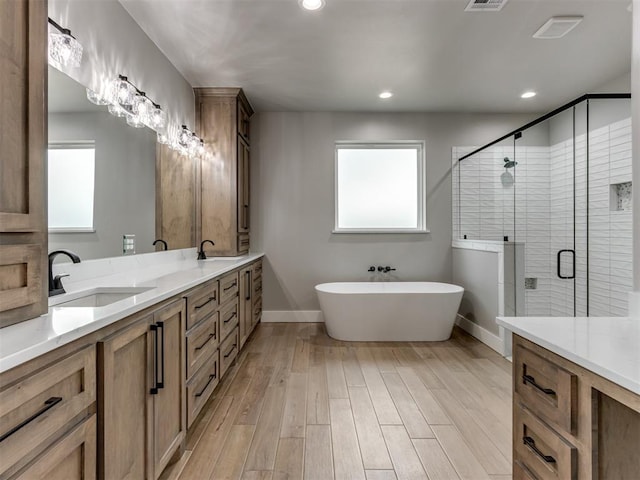 3134 NW 37th St, Newcastle, OK 73065 - bathroom with double vanity, a freestanding bath, a shower stall, wood finished floors, and baseboards