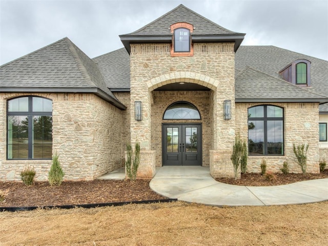 3134 NW 37th St, Newcastle, OK 73065 - entrance to property featuring french doors, a shingled roof, and stone siding