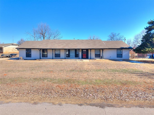 ranch-style house featuring brick siding, a front lawn, and a porch