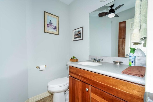 1901 E 15th St, Chandler, OK 74834 - half bathroom featuring vanity, toilet, ceiling fan, tile patterned flooring, and baseboards