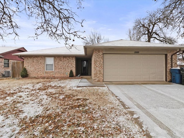 view of front of home with a garage and central air condition unit