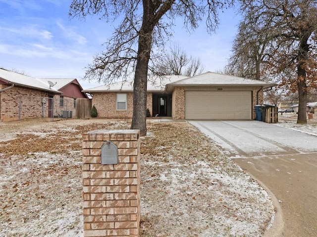 view of front of property featuring a garage and central air condition unit