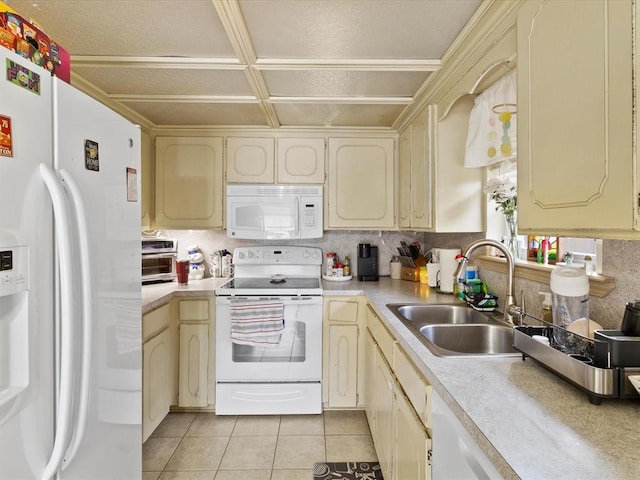 kitchen featuring light tile patterned flooring, sink, white appliances, and cream cabinetry