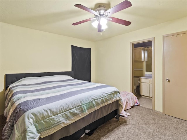 bedroom featuring light colored carpet, ceiling fan, and ensuite bathroom