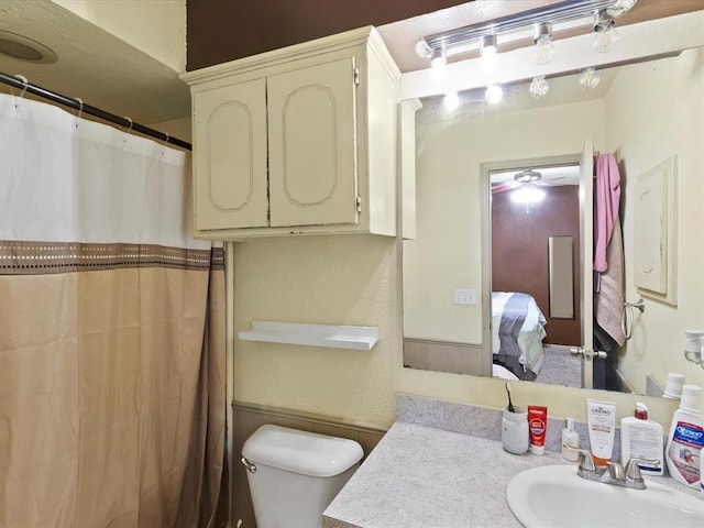 bathroom featuring vanity, walk in shower, and toilet