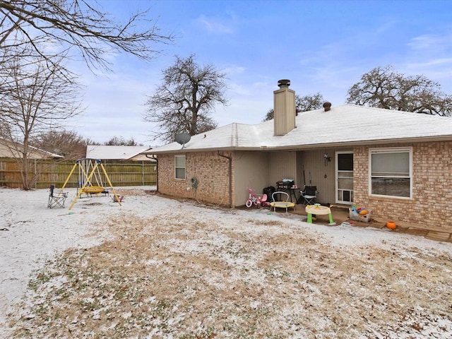 snow covered property featuring a playground