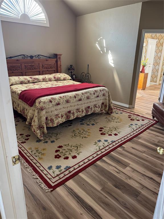 bedroom featuring lofted ceiling and wood-type flooring