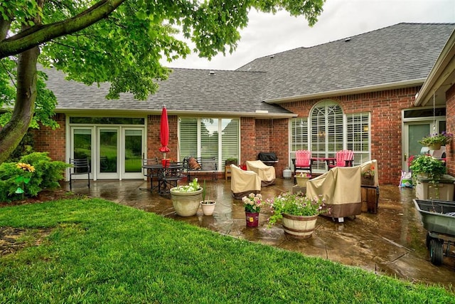 rear view of house with a patio and a lawn