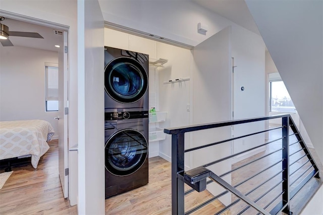 841 NW 6th St, Oklahoma City, OK 73106 - laundry area featuring stacked washing machine and dryer, light wood-style floors, baseboards, and ceiling fan