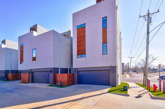 841 NW 6th St, Oklahoma City, OK 73106 - contemporary home with a garage, stucco siding, driveway, and brick siding
