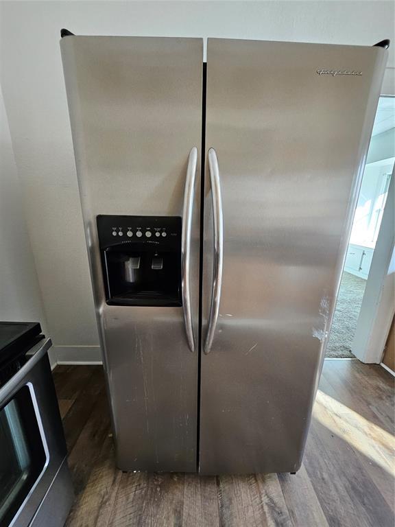 room details featuring stainless steel appliances and dark hardwood / wood-style floors