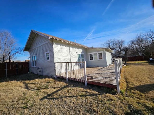 back of property with a wooden deck and a yard