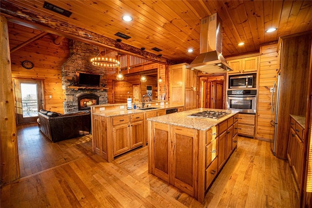 kitchen featuring a kitchen island, appliances with stainless steel finishes, island range hood, sink, and light wood-type flooring