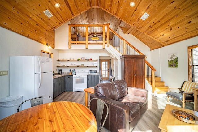 living room with light hardwood / wood-style floors, high vaulted ceiling, and wooden ceiling