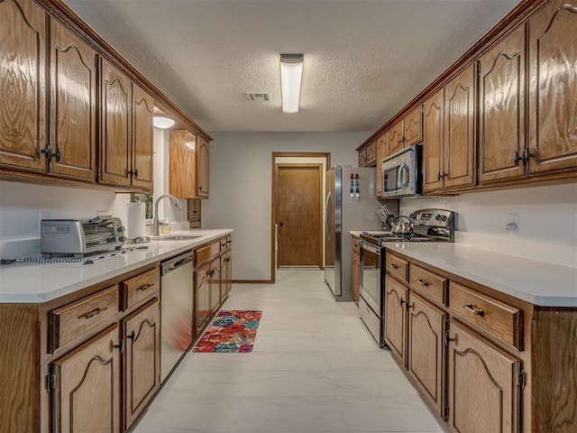 2108 Barton St Unit 2110, Norman, OK 73072 - kitchen featuring a textured ceiling, visible vents, appliances with stainless steel finishes, a sink, and a toaster