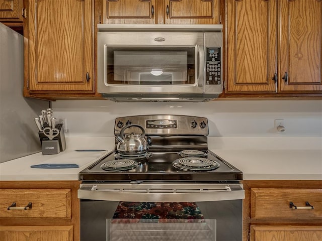 2108 Barton St Unit 2110, Norman, OK 73072 - kitchen with brown cabinets, light countertops, and appliances with stainless steel finishes