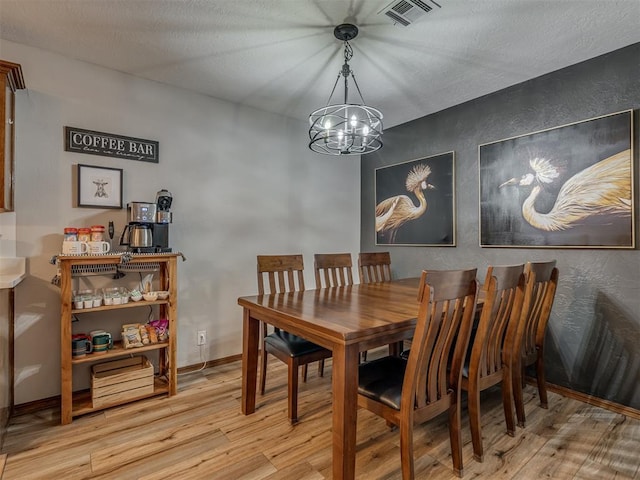 2108 Barton St Unit 2110, Norman, OK 73072 - dining area with visible vents, a textured wall, a chandelier, and wood finished floors