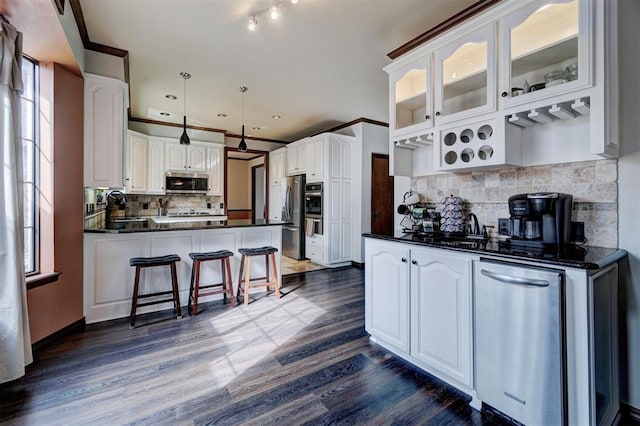 kitchen with white cabinetry, appliances with stainless steel finishes, sink, and hanging light fixtures