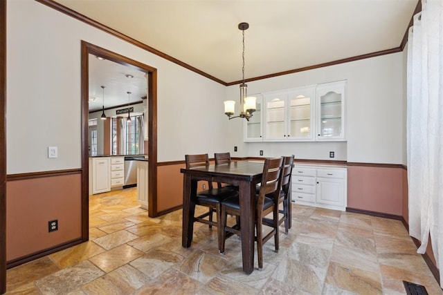 1408 NW 147th St, Edmond, OK 73013 - dining area featuring stone tile floors, a chandelier, and ornamental molding