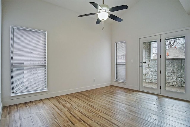 unfurnished room featuring light hardwood / wood-style flooring, high vaulted ceiling, and ceiling fan