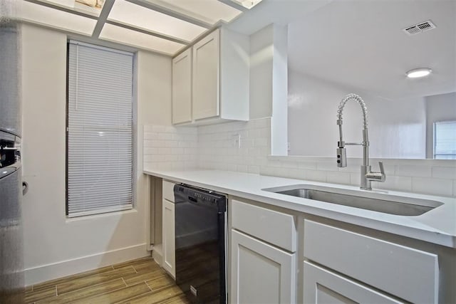 kitchen with dishwasher, sink, white cabinets, decorative backsplash, and light hardwood / wood-style flooring