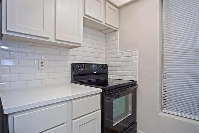 kitchen featuring black electric range oven and white cabinets