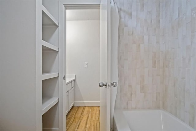 bathroom featuring hardwood / wood-style flooring, vanity, and shower / bath combo with shower curtain