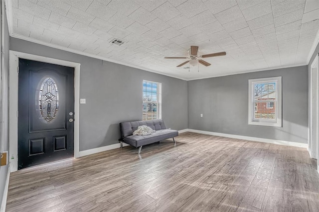 unfurnished room with a healthy amount of sunlight, crown molding, and light hardwood / wood-style floors