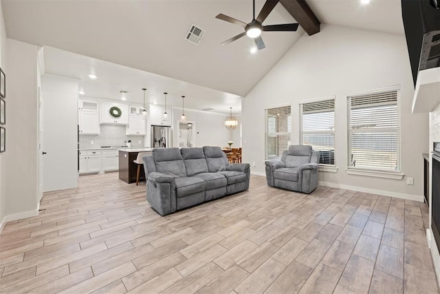 living room featuring beam ceiling, a fireplace, visible vents, light wood-style flooring, and a ceiling fan