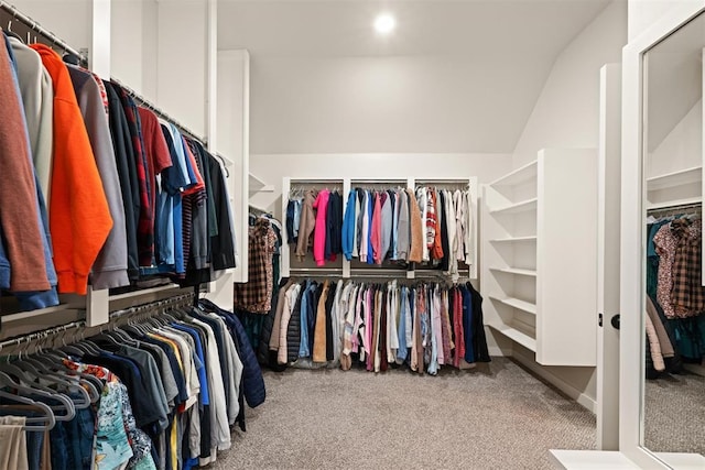 spacious closet with vaulted ceiling and light colored carpet