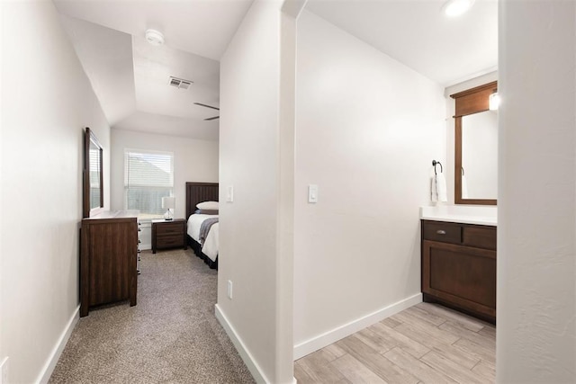 corridor featuring light wood finished floors, visible vents, and baseboards