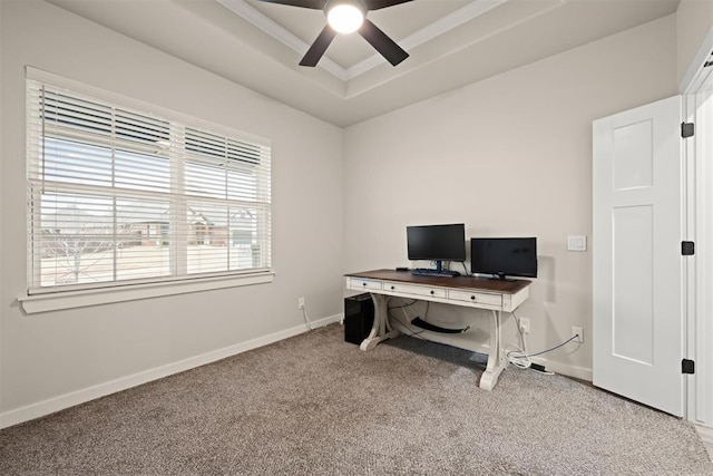 carpeted office space with baseboards, a tray ceiling, and ceiling fan