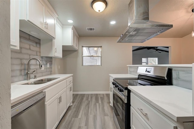 kitchen with sink, appliances with stainless steel finishes, white cabinets, island exhaust hood, and backsplash