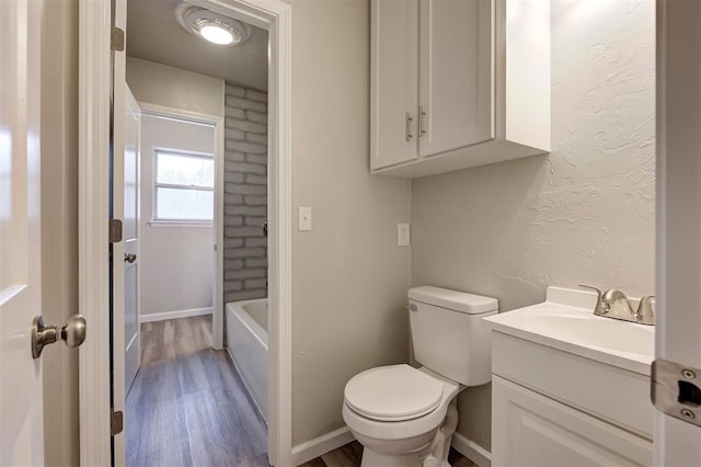 bathroom with vanity, toilet, a bathing tub, and wood-type flooring