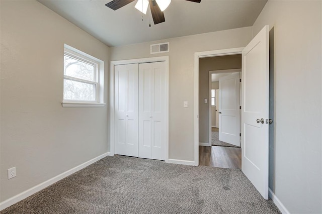 unfurnished bedroom featuring ceiling fan, a closet, and carpet