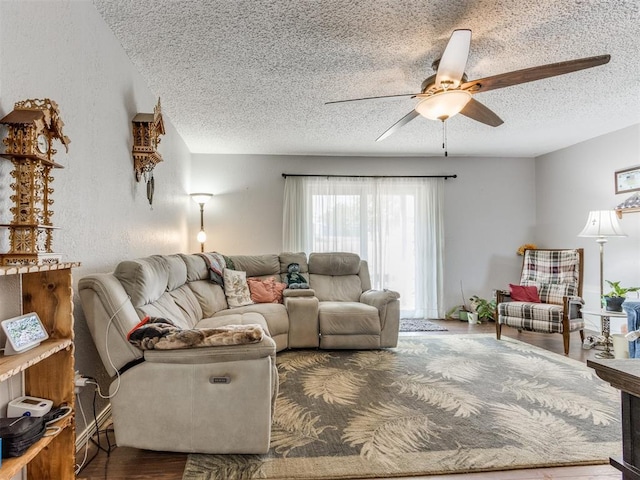 living room featuring hardwood / wood-style flooring, ceiling fan, and a textured ceiling