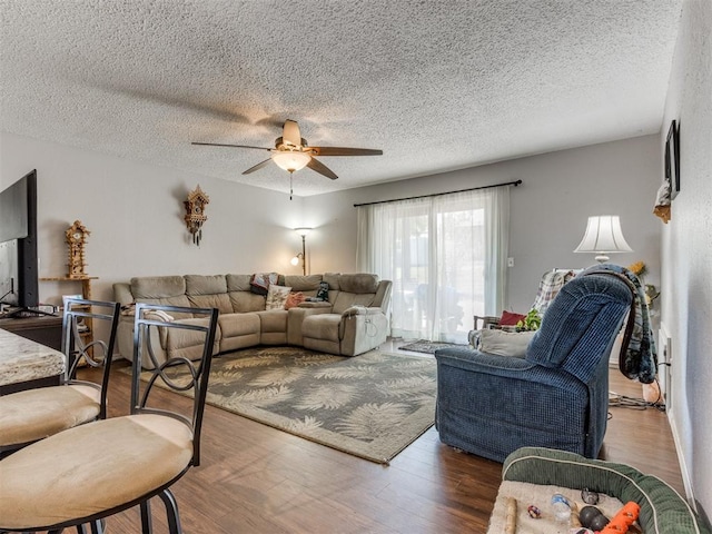 living room with dark hardwood / wood-style floors, a textured ceiling, and ceiling fan