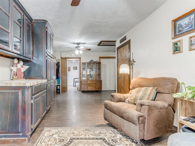 living room with dark hardwood / wood-style flooring and ceiling fan