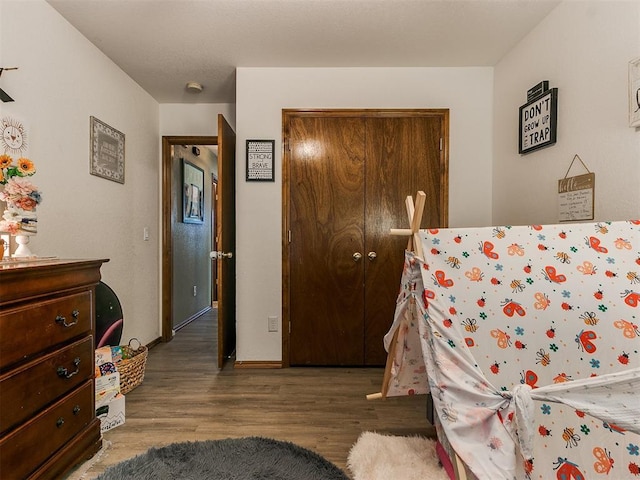 bedroom with dark hardwood / wood-style flooring and a closet