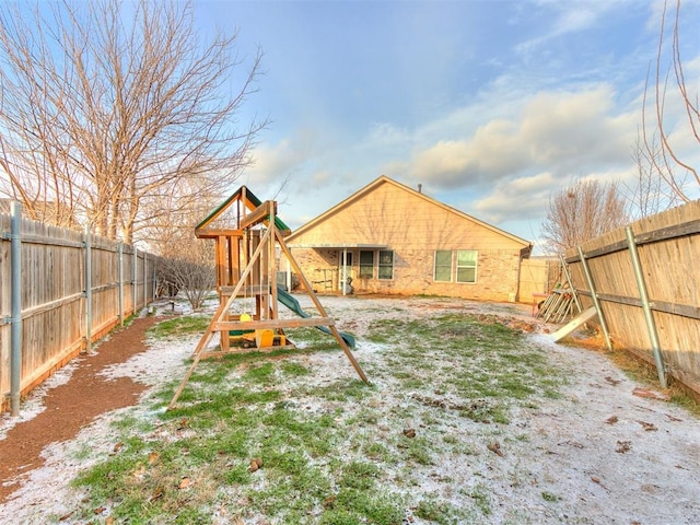 rear view of house featuring a playground