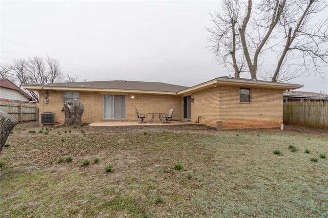 rear view of property featuring central AC unit, a yard, and a patio