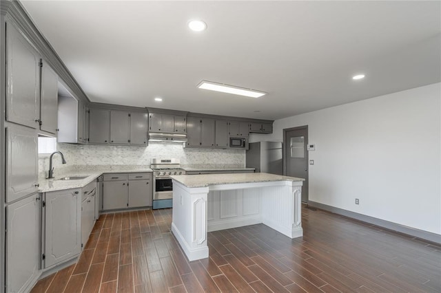 kitchen with sink, gray cabinetry, a center island, appliances with stainless steel finishes, and decorative backsplash