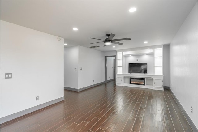 unfurnished living room with dark hardwood / wood-style floors and ceiling fan