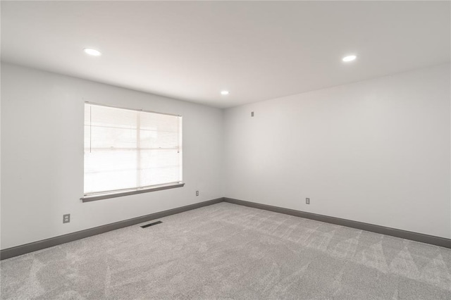 unfurnished room featuring light carpet