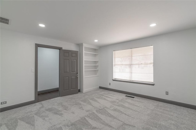 interior space with built in shelves and light carpet