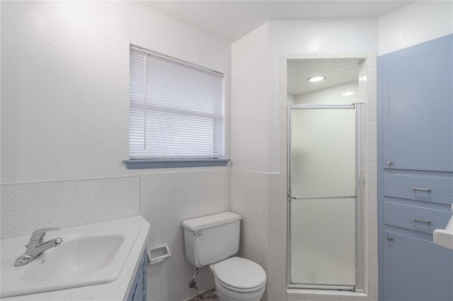 bathroom with walk in shower, vanity, toilet, and tile walls