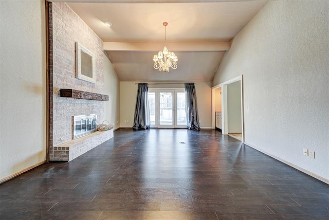 unfurnished living room featuring lofted ceiling with beams, a chandelier, a textured wall, a fireplace, and dark wood-style floors