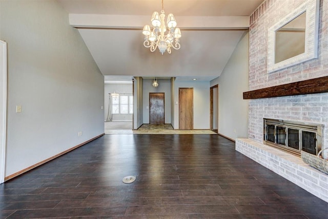 unfurnished living room featuring a notable chandelier, baseboards, lofted ceiling with beams, a brick fireplace, and wood finished floors